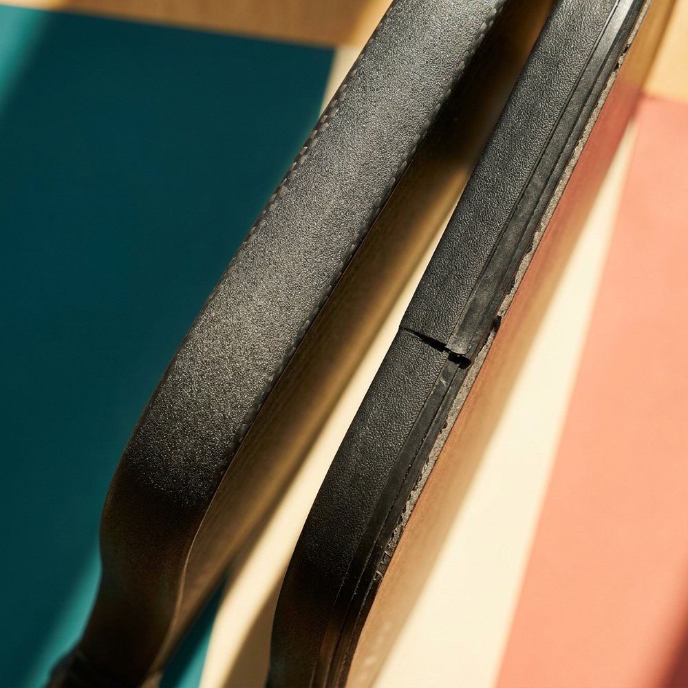 Two pickleball paddle edges compared, one a continuous seamless wrapped skin and one a fitted edge guard with a visible seam