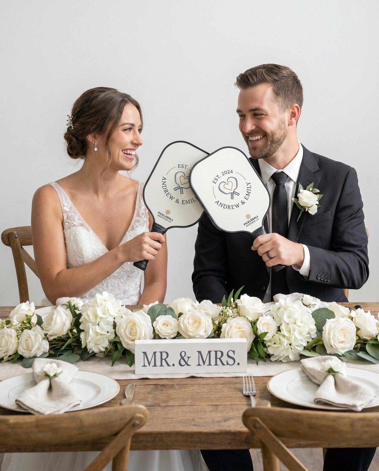 A couple with custom wedding pickleball paddles at their reception