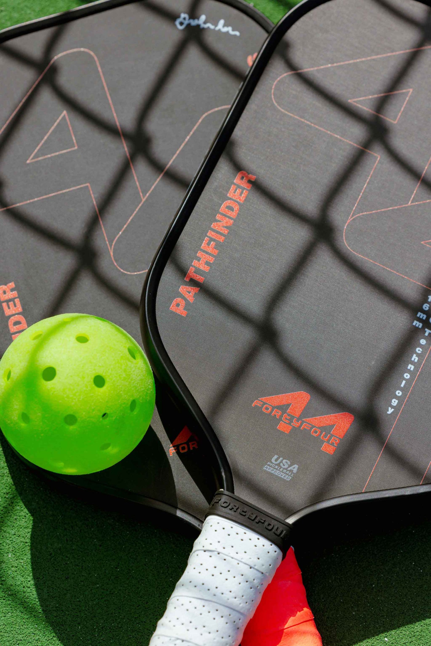 Custom Pickleball paddle with Custom green pickleball on a green surface, featuring 'Pathfinder' branding.