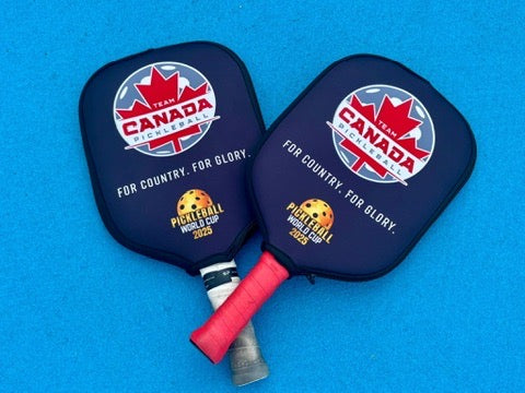 Two custom pickleball paddles with Team Canada branding on a blue background